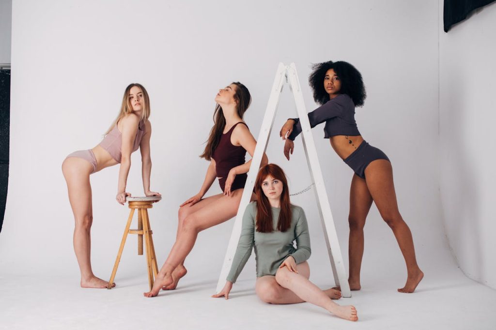 A group of diverse women posing in trendy lingerie during a studio photoshoot.